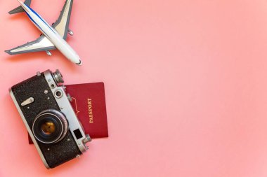 Düz Lay oyuncak uçak, vintage fotoğraf makinesi ve pasaport üzerinde pembe renkli pastel trendy modern moda arka plan ile. Tatil seyahat yaz hafta sonu deniz macera seyahat kavramı