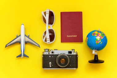 Çınar, bağbozumu kamera, pasaport, küre ve sarı renkli şık modern moda arka plan üzerinde güneş gözlüğü ile düz yatıyordu. Tatil seyahat yaz hafta sonu deniz macera seyahat kavramı