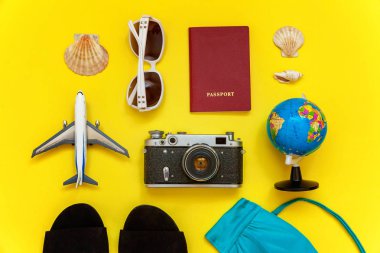 Düz Lay Bikini, çınar, bağbozumu kamera, küre, pasaport, güneş gözlüğü ve kabuk üzerinde sarı renkli şık modern moda arka plan ile. Tatil seyahat yaz hafta sonu deniz macera seyahat kavramı
