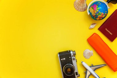 Güneş kremi, çınar, bağbozumu kamera, pasaport, dünya, güneş gözlüğü ve kabuk sarı renkli şık modern moda arka plan üzerinde ile düz yatıyordu. Tatil seyahat yaz hafta sonu deniz macera seyahat kavramı
