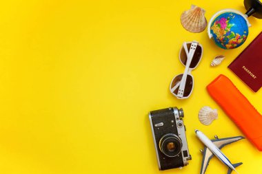 Güneş kremi, çınar, bağbozumu kamera, pasaport, dünya, güneş gözlüğü ve kabuk sarı renkli şık modern moda arka plan üzerinde ile düz yatıyordu. Tatil seyahat yaz hafta sonu deniz macera seyahat kavramı