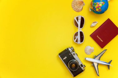 Düz Lay çınar, bağbozumu kamera, pasaport, dünya, güneş gözlüğü ve kabuk üzerinde sarı renkli şık modern moda arka plan ile. Tatil seyahat yaz hafta sonu deniz macera seyahat kavramı