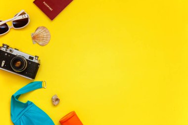 Düz Lay Bikini, çınar, bağbozumu kamera, pasaport, Güneş kremi, güneş gözlüğü ve kabuk üzerinde sarı renkli şık modern moda arka plan ile. Tatil seyahat yaz hafta sonu deniz macera seyahat kavramı
