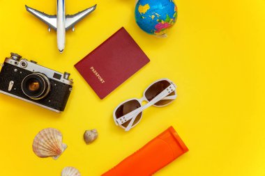 Düz Lay Bikini, çınar, bağbozumu kamera, dünya, Güneş kremi, pasaport, güneş gözlüğü ve kabuk üzerinde sarı renkli şık modern moda arka plan ile. Tatil seyahat yaz hafta sonu deniz macera seyahat kavramı