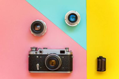 Saint-Petersburg, Rusya-13 Nisan 2018: Vintage film fotoğraf kamera objektifi film rulo ve aksesuarları sarı, pembe ve mavi renkli pastel trendy modern moda pin-up arka plan üzerinde. Teknoloji geliştirme fotoğrafçı hobi klasik bellek gezi conce
