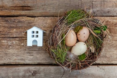 Minyatür beyaz oyuncak model house rustik eski vintage ahşap arka plan üzerinde yumurta yuvada aittir. Eko köyü çevre gayrimenkul ipotek Emlak sigorta rüya ev ekoloji yatırım kavramı