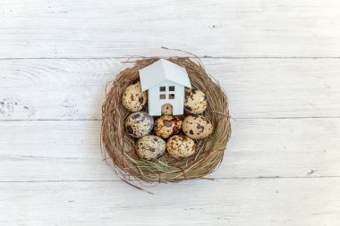 Minyatür beyaz oyuncak model house rustik eski vintage ahşap arka plan üzerinde yumurta yuvada aittir. Eko köyü çevre gayrimenkul ipotek Emlak sigorta rüya ev ekoloji yatırım kavramı