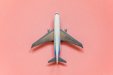 Sadece düz yatıyordu tasarım minyatür oyuncak model uçak pembe pastel renkli trendy Kağıt arka plan ile. Uçak tatil yaz hafta sonu deniz macera seyahat kavramı ile seyahat
