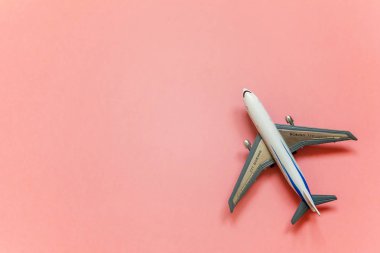 Sadece düz yatıyordu tasarım minyatür oyuncak model uçak pembe pastel renkli trendy Kağıt arka plan ile. Uçak tatil yaz hafta sonu deniz macera seyahat kavramı ile seyahat