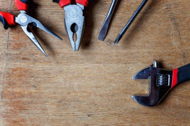 Çeşitli onarım araçları: pense, tornavida, eski rustik ahşap arka plan ve metin boşaltmak için yer ayarlanabilir anahtarı