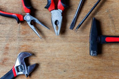 Çeşitli onarım araçları: pense, tornavida, çekiç, eski rustik ahşap arka plan ve metin boşaltmak için yer ayarlanabilir anahtarı