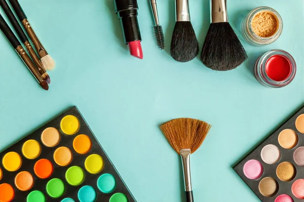 Mavi arka plan üzerinde göz farı makyaj ve kozmetik farklı tonlar için Araçlar