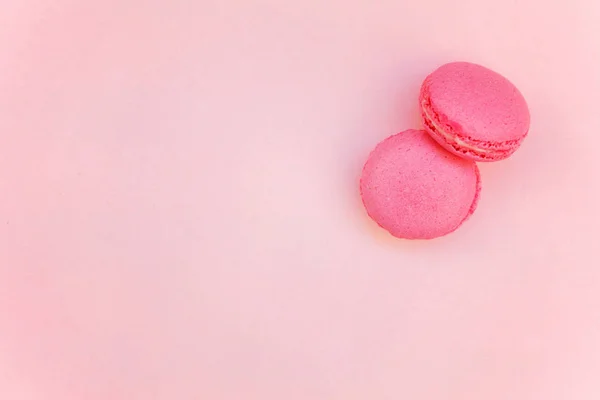 柔らかい甘いピンクのパステル調のミニのピンクのマカロンやマカロン フランス デザート ケーキの平面図フラット レイアウト背景紙 — ストック写真