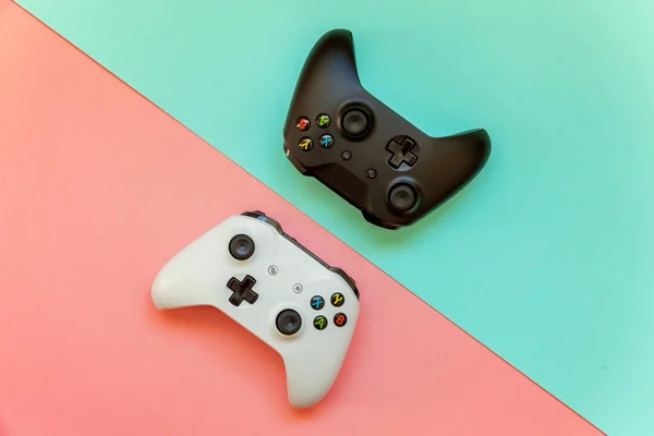 Saint-Petersburg, Rusya-13 Nisan 2018: siyah ve beyaz joystick xbox bir s gamepad, pembe ve mavi pastel renkli arka plan üzerinde oyun konsolu. Bilgisayar oyun yarışması video oyunu denetim çatışma kavramı