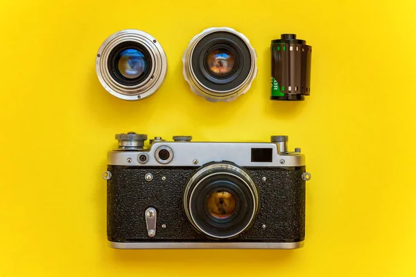 Saint-Petersburg, Rusya-13 Nisan 2018: Vintage film fotoğraf kamera objektifi film rulo ve aksesuarları sarı renkli şık modern moda pin-up arka plan üzerinde. Teknoloji geliştirme fotoğrafçı hobi klasik bellek gezi konsepti. Üstten görünüm
