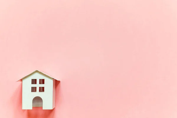 Minyatür beyaz oyuncak evi pembe pastel renkli kağıt trendy arka plan üzerinde sadece düz yatıyordu tasarım. Mortgage Emlak sigorta rüya ev concept
