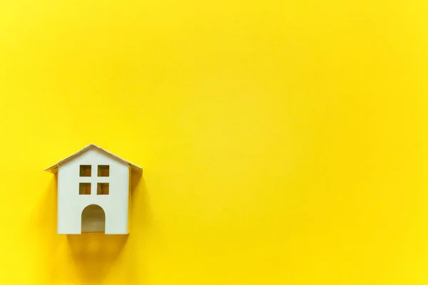 Minyatür beyaz oyuncak ev sarı renkli kağıt trendy arka plan üzerinde sadece düz yatıyordu tasarım. Mortgage Emlak sigorta rüya ev concept