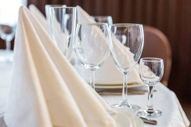 Gözlük, bir piramit katlanmış peçete akşam yemeği için restoran rahat iç görev yaptı. Düğün süslemeleri ve maddeler için gıda, beyaz masa örtüsü ile kaplı büyük bir tabloda catering hizmeti göre düzenlenmiş