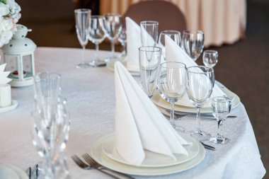 Gözlük, bir piramit katlanmış peçete akşam yemeği için restoran rahat iç görev yaptı. Düğün süslemeleri ve maddeler için gıda, beyaz masa örtüsü ile kaplı büyük bir tabloda catering hizmeti göre düzenlenmiş