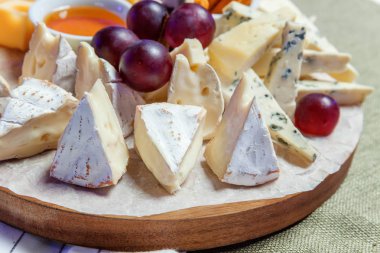 Peynir farklı tipleri ile Yönetim Kurulu: Dor blu, chedar, Parmesan, brie, tatlım sos, parmak ekmek ve üzüm. Restoran menü plaka