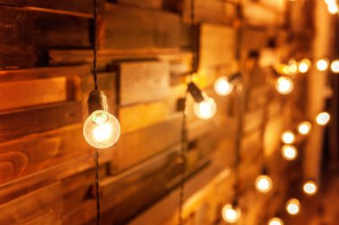 Ampulleri ahşap arka plan üzerinde mockup poster asılı. Arka plan ağaç plakalar lambaları