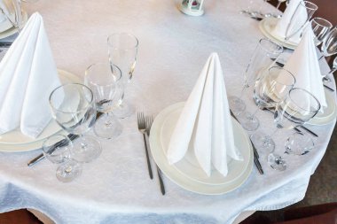 Gözlük, bir piramit katlanmış peçete akşam yemeği için restoran rahat iç görev yaptı. Düğün süslemeleri ve maddeler için gıda, beyaz masa örtüsü ile kaplı büyük bir tabloda catering hizmeti göre düzenlenmiş