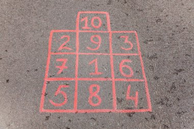 Çocuk sokak mobil oyun ile çizilmiş tebeşir karelere atlamak için.