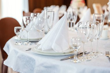 Gözlük, bir piramit katlanmış peçete akşam yemeği için restoran rahat iç görev yaptı. Düğün süslemeleri ve maddeler için gıda, beyaz masa örtüsü ile kaplı büyük bir tabloda catering hizmeti göre düzenlenmiş