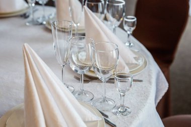 Gözlük, bir piramit katlanmış peçete akşam yemeği için restoran rahat iç görev yaptı. Düğün süslemeleri ve maddeler için gıda, beyaz masa örtüsü ile kaplı büyük bir tabloda catering hizmeti göre düzenlenmiş