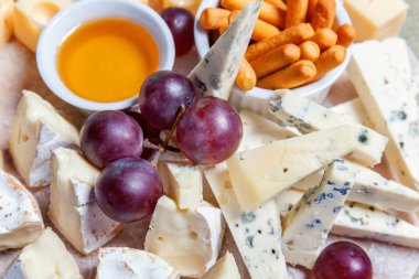 Peynir farklı tipleri ile Yönetim Kurulu: Dor blu, chedar, Parmesan, brie, tatlım sos, parmak ekmek ve üzüm. Restoran menü plaka