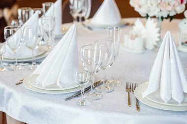 Gözlük, bir piramit katlanmış peçete akşam yemeği için restoran rahat iç görev yaptı. Düğün süslemeleri ve maddeler için gıda, beyaz masa örtüsü ile kaplı büyük bir tabloda catering hizmeti göre düzenlenmiş