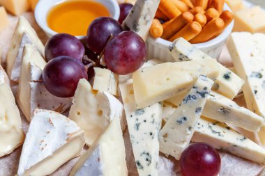 Peynir farklı tipleri ile Yönetim Kurulu: Dor blu, chedar, Parmesan, brie, tatlım sos, parmak ekmek ve üzüm. Restoran menü plaka