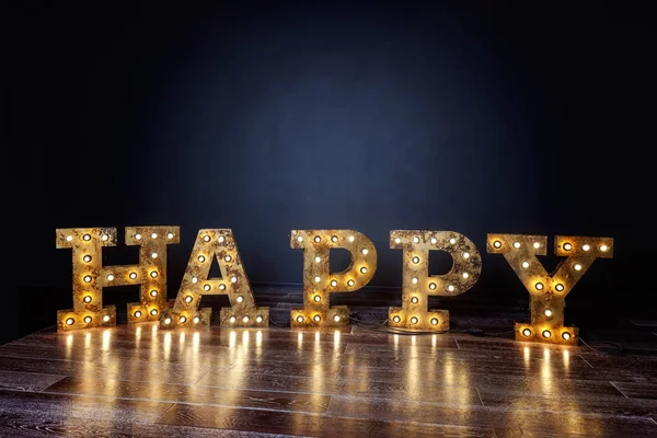 Happy letters word with glowing light retro bulbs standing on a floor