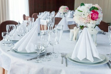 Gözlük, bir piramit katlanmış peçete akşam yemeği için restoran rahat iç görev yaptı. Düğün süslemeleri ve maddeler için gıda, beyaz masa örtüsü ile kaplı büyük bir tabloda catering hizmeti göre düzenlenmiş
