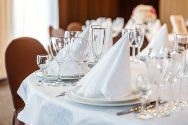 Gözlük, bir piramit katlanmış peçete akşam yemeği için restoran rahat iç görev yaptı. Düğün süslemeleri ve maddeler için gıda, beyaz masa örtüsü ile kaplı büyük bir tabloda catering hizmeti göre düzenlenmiş