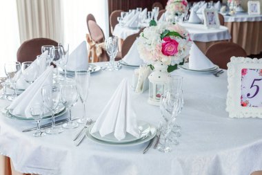 Gözlük, bir piramit katlanmış peçete akşam yemeği için restoran rahat iç görev yaptı. Düğün süslemeleri ve maddeler için gıda, beyaz masa örtüsü ile kaplı büyük bir tabloda catering hizmeti göre düzenlenmiş