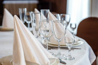 Gözlük, bir piramit katlanmış peçete akşam yemeği için restoran rahat iç görev yaptı. Düğün süslemeleri ve maddeler için gıda, beyaz masa örtüsü ile kaplı büyük bir tabloda catering hizmeti göre düzenlenmiş