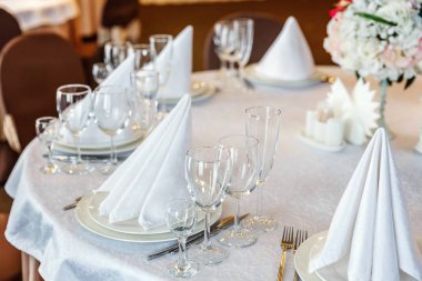 Gözlük, bir piramit katlanmış peçete akşam yemeği için restoran rahat iç görev yaptı. Düğün süslemeleri ve maddeler için gıda, beyaz masa örtüsü ile kaplı büyük bir tabloda catering hizmeti göre düzenlenmiş