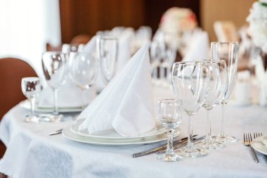 Gözlük, bir piramit katlanmış peçete akşam yemeği için restoran rahat iç görev yaptı. Düğün süslemeleri ve maddeler için gıda, beyaz masa örtüsü ile kaplı büyük bir tabloda catering hizmeti göre düzenlenmiş