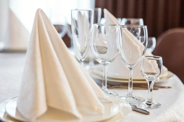 Gözlük, bir piramit katlanmış peçete akşam yemeği için restoran rahat iç görev yaptı. Düğün süslemeleri ve maddeler için gıda, beyaz masa örtüsü ile kaplı büyük bir tabloda catering hizmeti göre düzenlenmiş