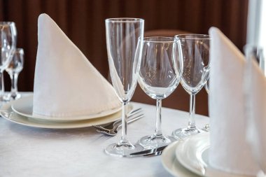 Gözlük, bir piramit katlanmış peçete akşam yemeği için restoran rahat iç görev yaptı. Düğün süslemeleri ve maddeler için gıda, beyaz masa örtüsü ile kaplı büyük bir tabloda catering hizmeti göre düzenlenmiş