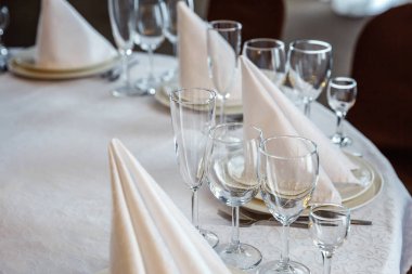 Gözlük, bir piramit katlanmış peçete akşam yemeği için restoran rahat iç görev yaptı. Düğün süslemeleri ve maddeler için gıda, beyaz masa örtüsü ile kaplı büyük bir tabloda catering hizmeti göre düzenlenmiş