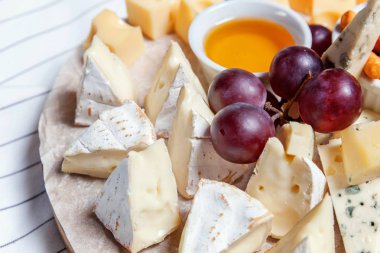 Peynir farklı tipleri ile Yönetim Kurulu: Dor blu, chedar, Parmesan, brie, tatlım sos, parmak ekmek ve üzüm. Restoran menü plaka