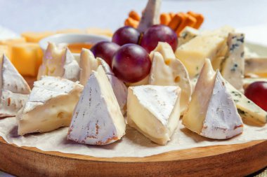 Peynir farklı tipleri ile Yönetim Kurulu: Dor blu, chedar, Parmesan, brie, tatlım sos, parmak ekmek ve üzüm. Restoran menü plaka
