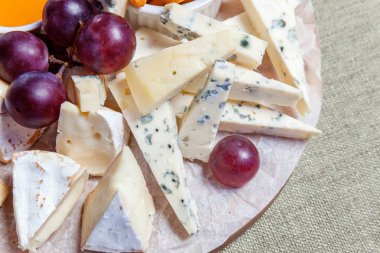 Peynir farklı tipleri ile Yönetim Kurulu: Dor blu, chedar, Parmesan, brie, tatlım sos, parmak ekmek ve üzüm. Restoran menü plaka