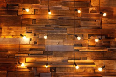 Ampulleri ahşap arka plan üzerinde mockup poster asılı. Arka plan ağaç plakalar lambaları