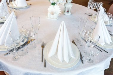 Gözlük, bir piramit katlanmış peçete akşam yemeği için restoran rahat iç görev yaptı. Düğün süslemeleri ve maddeler için gıda, beyaz masa örtüsü ile kaplı büyük bir tabloda catering hizmeti göre düzenlenmiş