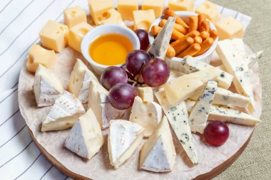 Peynir farklı tipleri ile Yönetim Kurulu: Dor blu, chedar, Parmesan, brie, tatlım sos, parmak ekmek ve üzüm. Restoran menü plaka