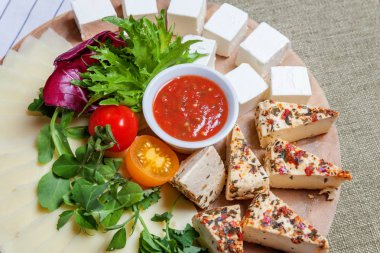 Farklı türde peyniri beyaz peynir-brynza, domates sos ve taze sebze ile yönetim kurulu. Restoran menü plaka