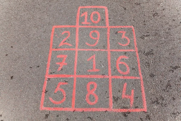 Children's street mobile game with hand-drawn chalk squares on which to jump.